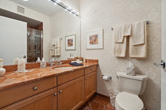 bathroom featuring tile patterned flooring, vanity, a shower with door, and toilet