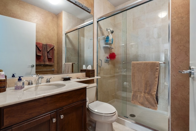 bathroom with a shower with shower door, vanity, and toilet