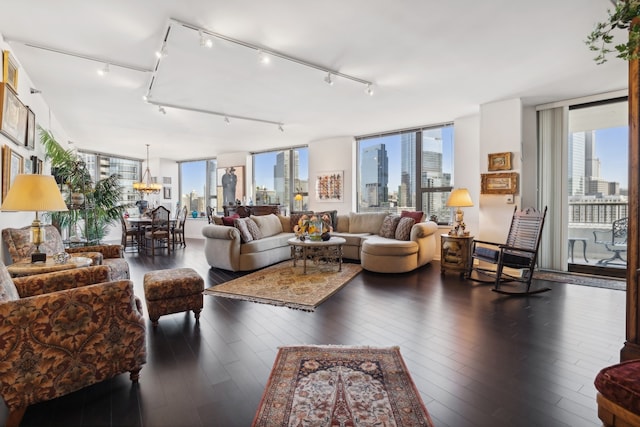 living room with a notable chandelier, floor to ceiling windows, and dark hardwood / wood-style flooring