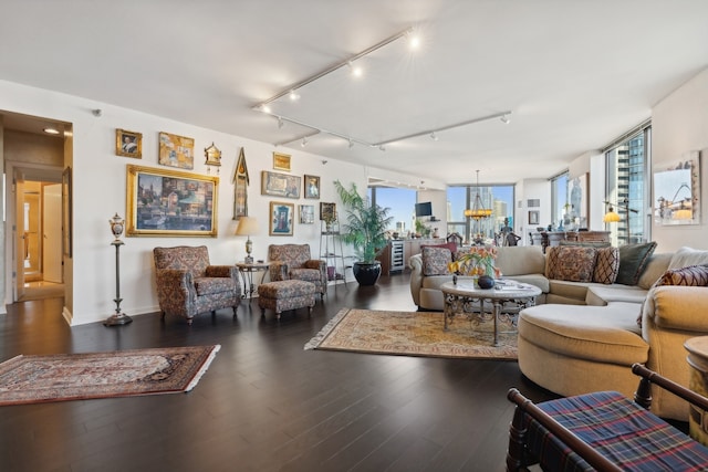 living room featuring track lighting, a notable chandelier, and dark hardwood / wood-style flooring