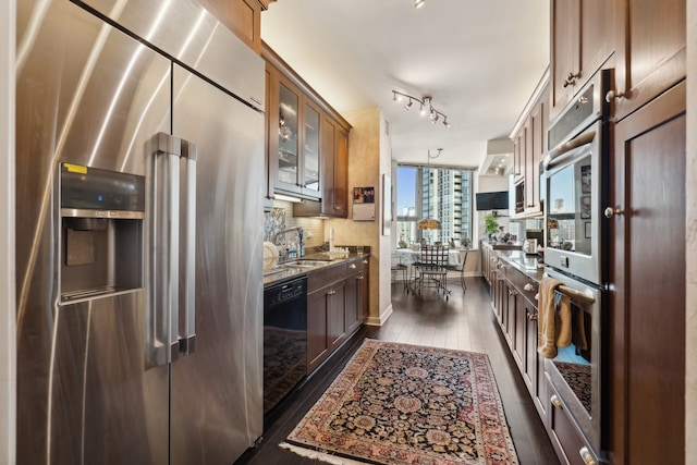 kitchen featuring decorative backsplash, stone countertops, sink, stainless steel appliances, and dark hardwood / wood-style floors