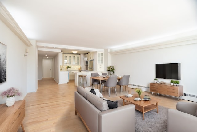 living room with a baseboard radiator and light hardwood / wood-style floors