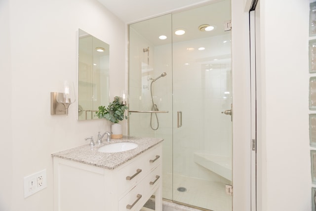 bathroom featuring walk in shower and vanity