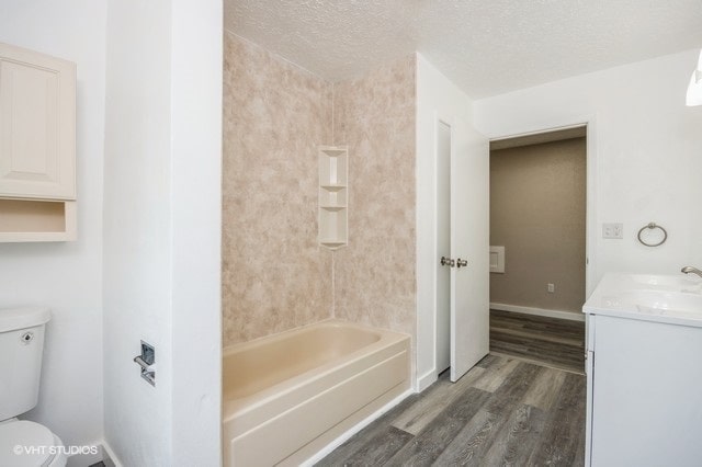 full bathroom featuring a textured ceiling, vanity, toilet, and hardwood / wood-style flooring