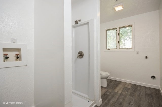 bathroom featuring hardwood / wood-style floors, toilet, and a textured ceiling