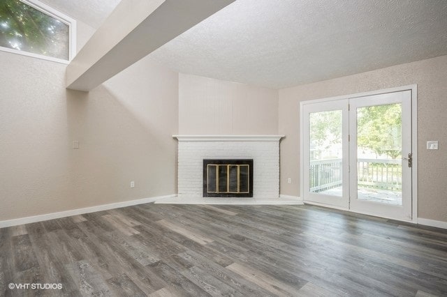 unfurnished living room featuring a textured ceiling, dark wood-type flooring, and a fireplace