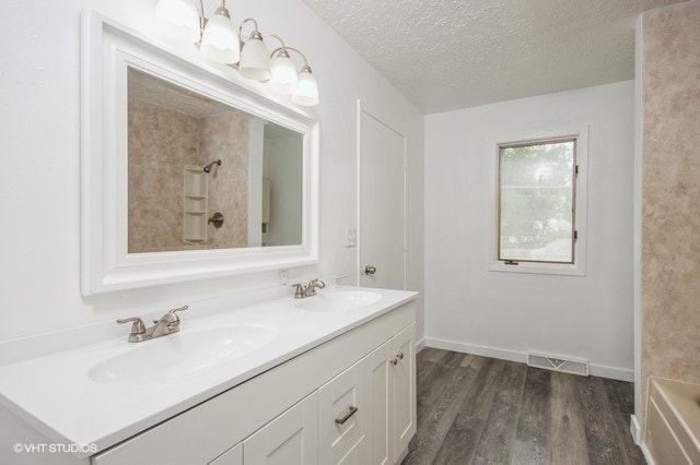 bathroom featuring a textured ceiling, vanity, and hardwood / wood-style flooring