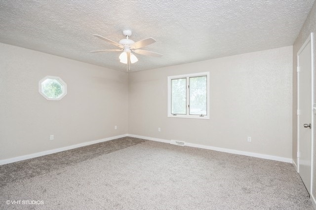 empty room with ceiling fan, a textured ceiling, and carpet floors