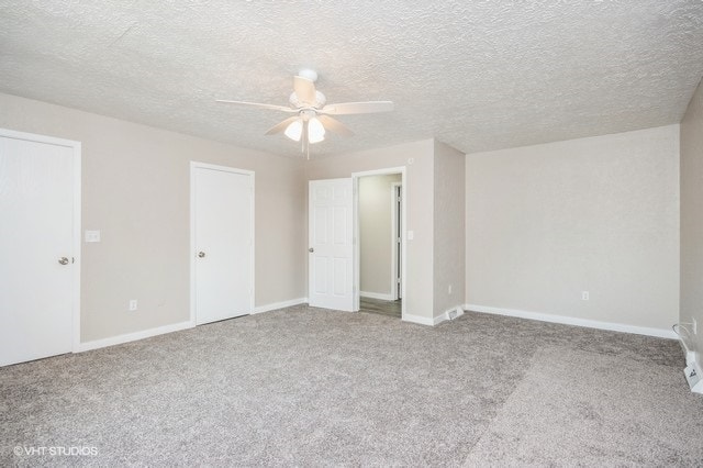 unfurnished bedroom with ceiling fan, light colored carpet, and a textured ceiling