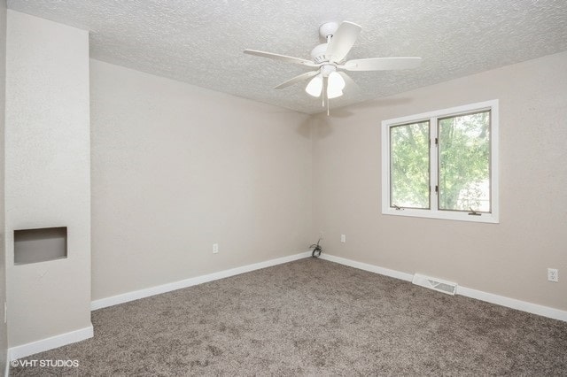 carpeted empty room with a textured ceiling and ceiling fan