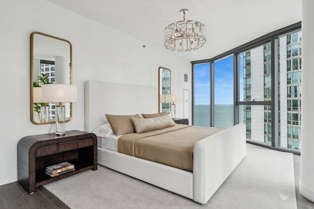 bedroom with access to outside, a chandelier, hardwood / wood-style floors, and multiple windows