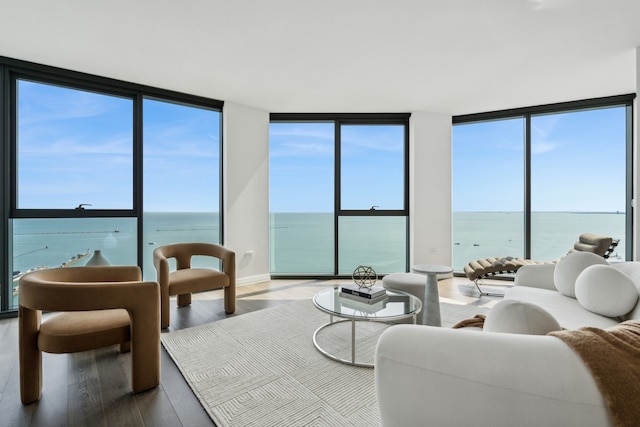 living room with plenty of natural light, a water view, and hardwood / wood-style flooring