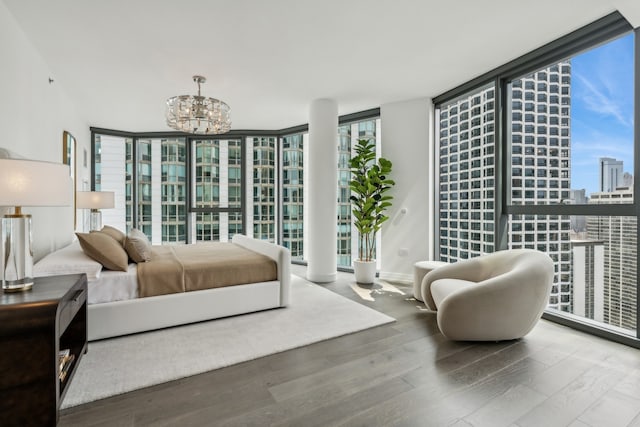 bedroom featuring hardwood / wood-style floors, a chandelier, and expansive windows