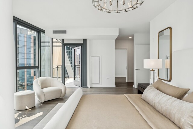 living room with wood-type flooring, an inviting chandelier, and expansive windows