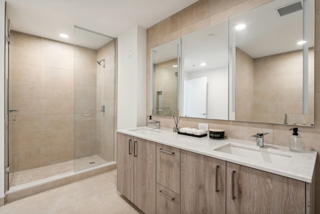 bathroom with tile walls, an enclosed shower, and vanity