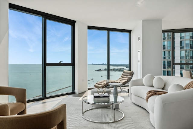 living room featuring a wall of windows and a water view