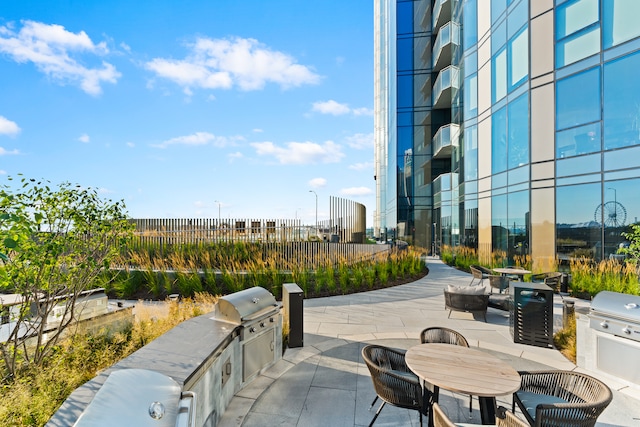 view of patio with a balcony, grilling area, and exterior kitchen