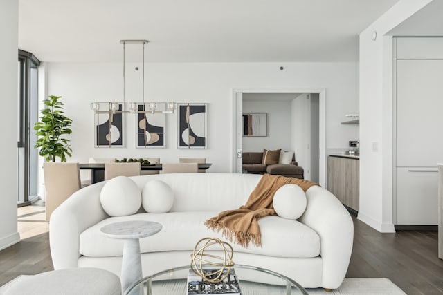 living room featuring a notable chandelier and dark wood-type flooring