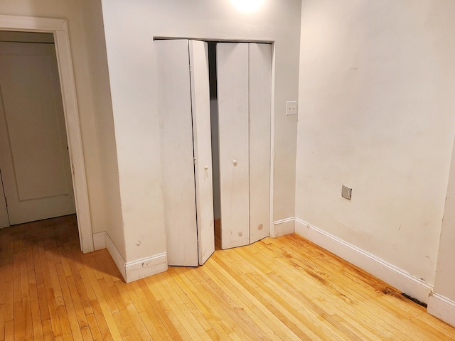 unfurnished bedroom with a closet and light hardwood / wood-style flooring