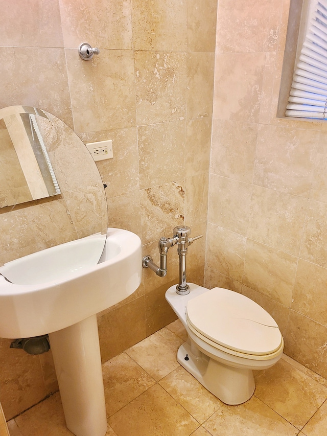 bathroom with tile walls and toilet