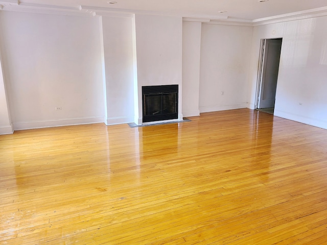 unfurnished living room with light wood-type flooring, crown molding, and heating unit