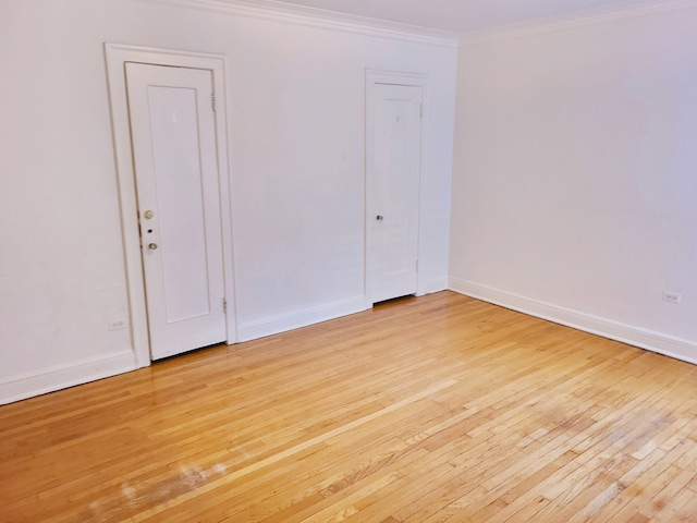 spare room with crown molding and light wood-type flooring