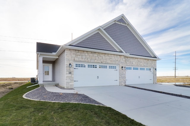 view of front of house with a garage, central AC unit, and a front lawn