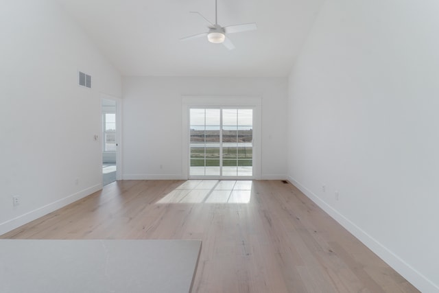 empty room with high vaulted ceiling, ceiling fan, and light hardwood / wood-style floors