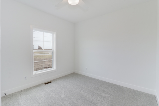 carpeted spare room with ceiling fan