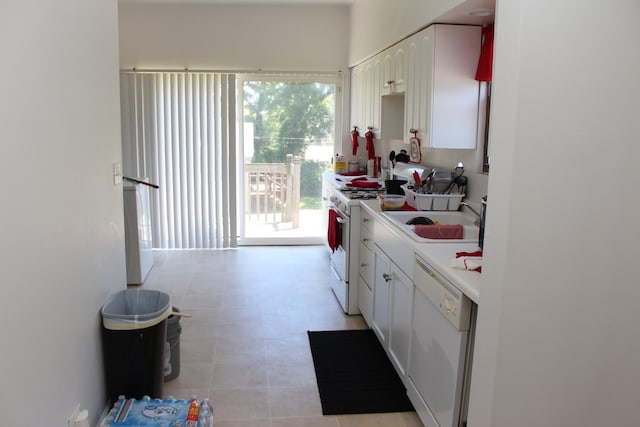 kitchen with white appliances, sink, and white cabinets