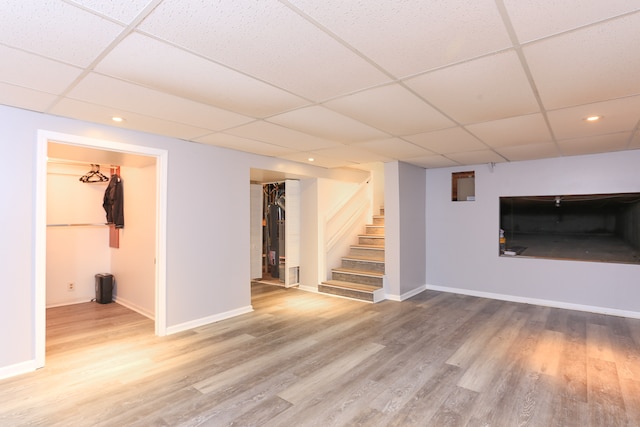 basement with a drop ceiling and wood-type flooring