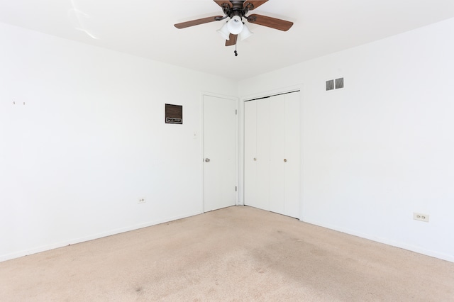 carpeted spare room with ceiling fan