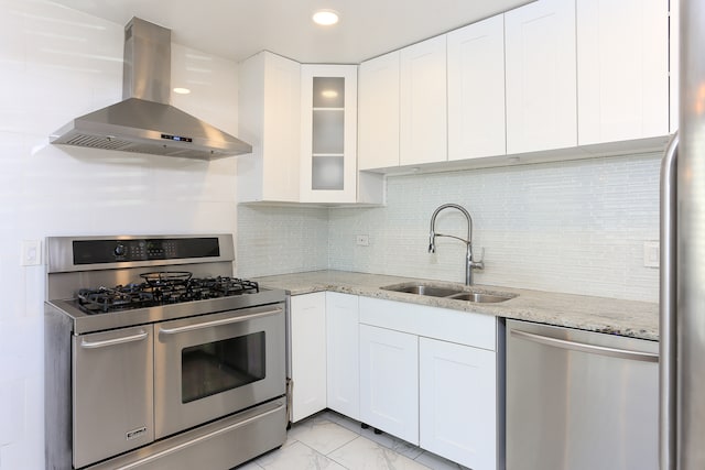 kitchen with sink, white cabinetry, wall chimney range hood, and stainless steel appliances