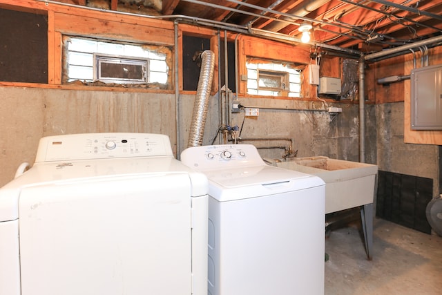 laundry room with a wealth of natural light, sink, electric panel, and washing machine and clothes dryer