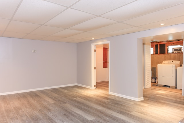 unfurnished room featuring a drop ceiling, washer and dryer, and light hardwood / wood-style floors