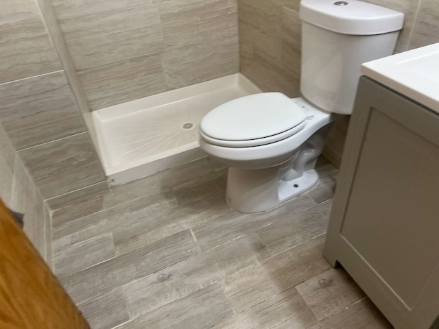 bathroom with vanity, a shower, and toilet