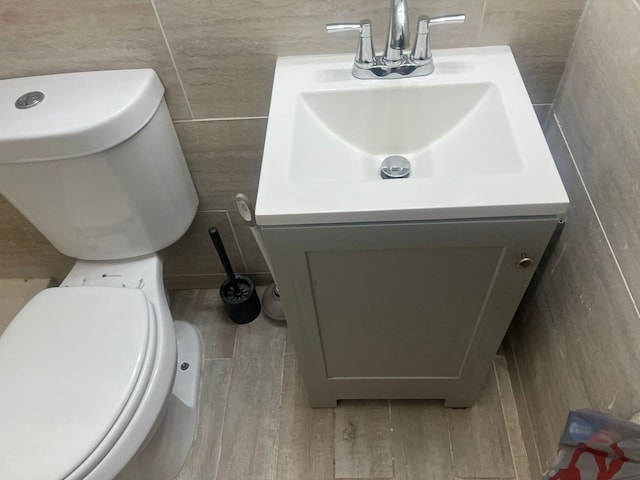 bathroom with wood-type flooring, vanity, and toilet