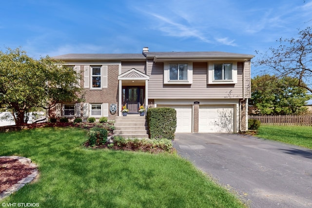 bi-level home with a garage and a front lawn