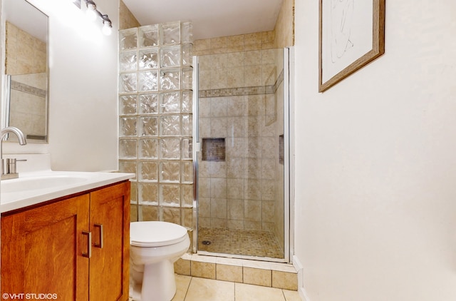 bathroom featuring tile patterned flooring, a shower with shower door, toilet, and vanity