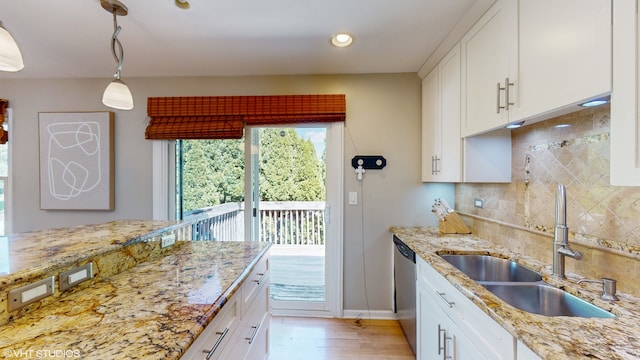 kitchen featuring tasteful backsplash, light hardwood / wood-style flooring, sink, and white cabinets