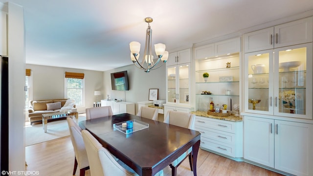 dining room featuring light wood-type flooring and a chandelier