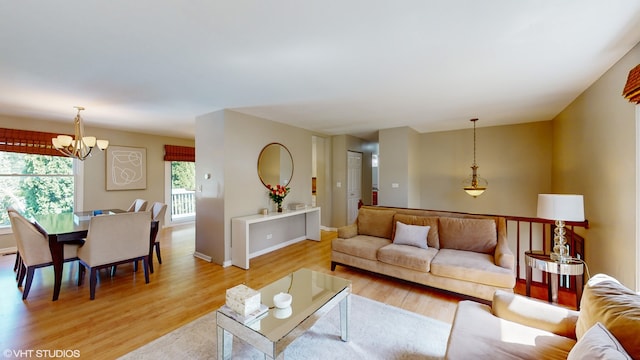 living room featuring light wood-type flooring and a chandelier