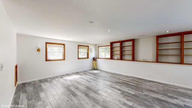 unfurnished room featuring a healthy amount of sunlight and wood-type flooring