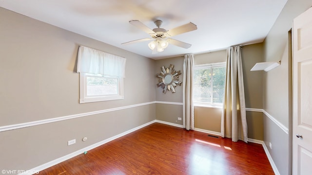 empty room featuring ceiling fan and dark hardwood / wood-style flooring