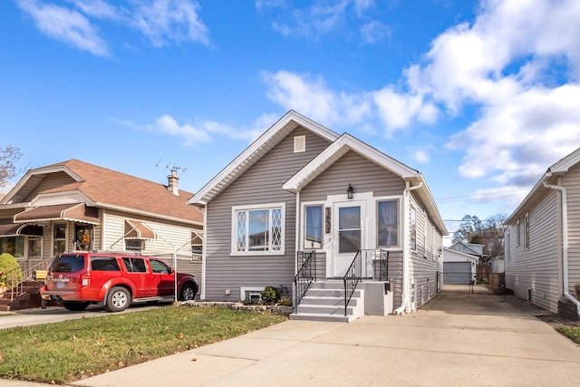 bungalow-style house featuring a front yard, a garage, and an outdoor structure