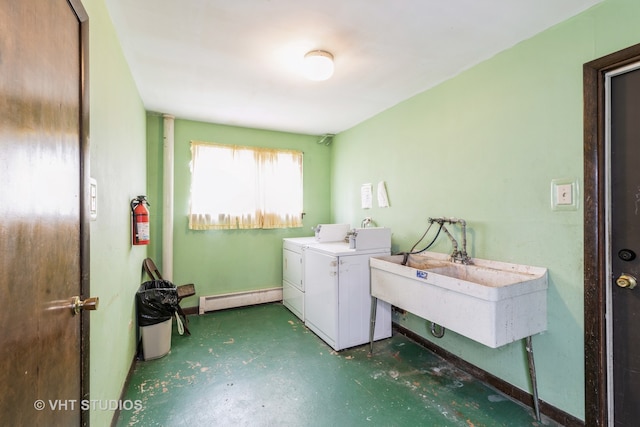 washroom with washing machine and dryer, sink, and a baseboard radiator