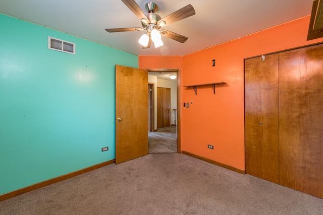 unfurnished bedroom featuring light colored carpet, a closet, and ceiling fan