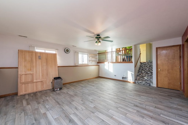 interior space featuring ceiling fan, wood-type flooring, and heating unit