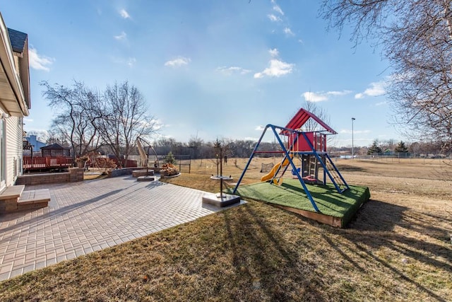 view of playground with a lawn and a patio area