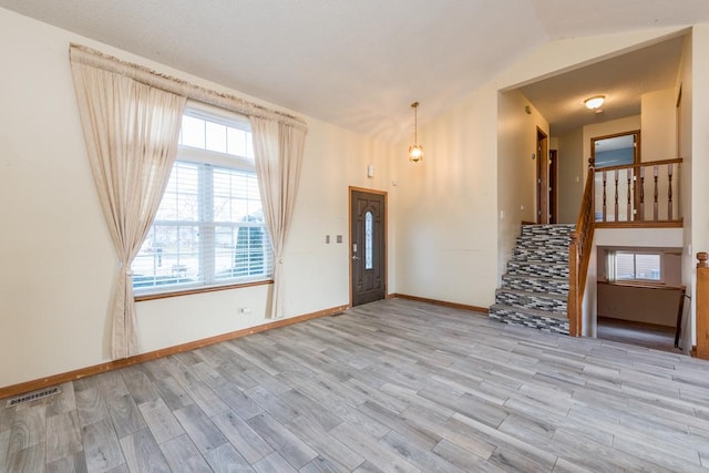 foyer with light hardwood / wood-style floors and lofted ceiling